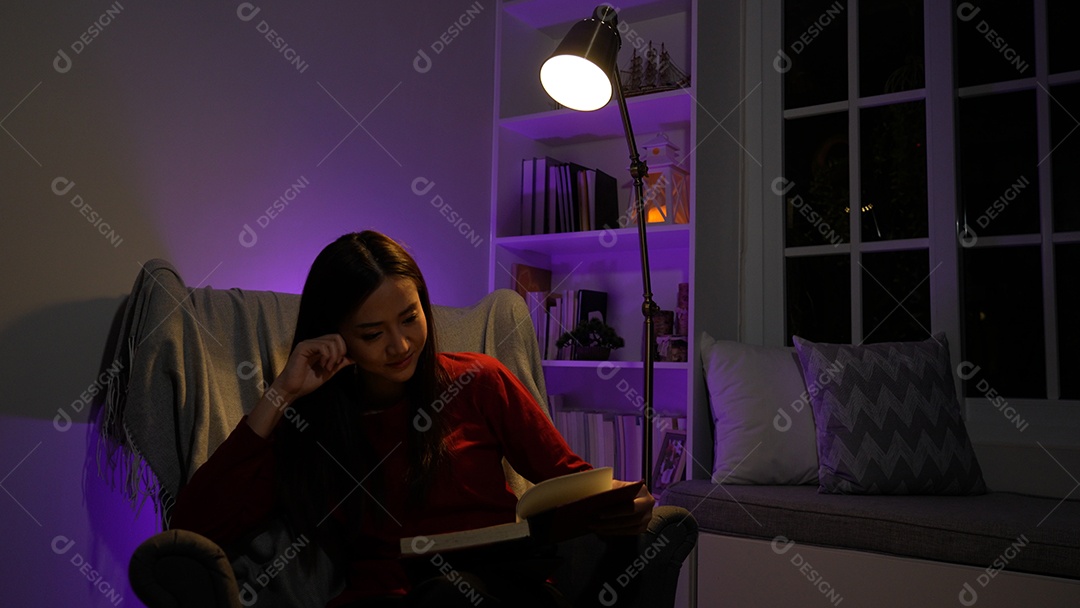 Jovem asiática sentada trabalhando horas extras fazendo negócios tardios no escritório à noite