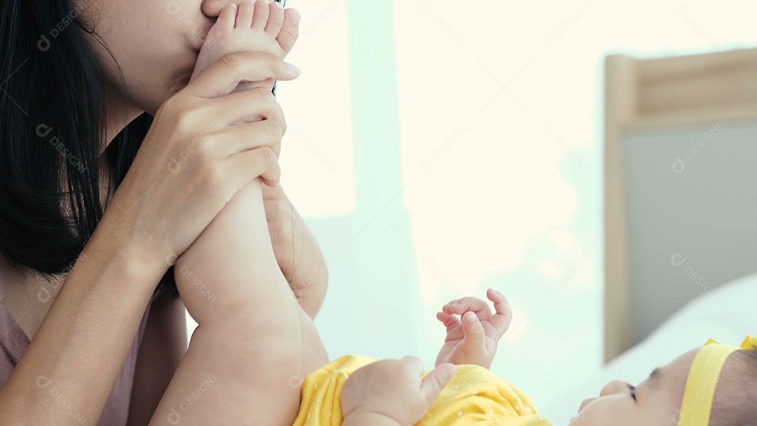 Mãe asiática com seu bebê recém-nascido na cama de manhã