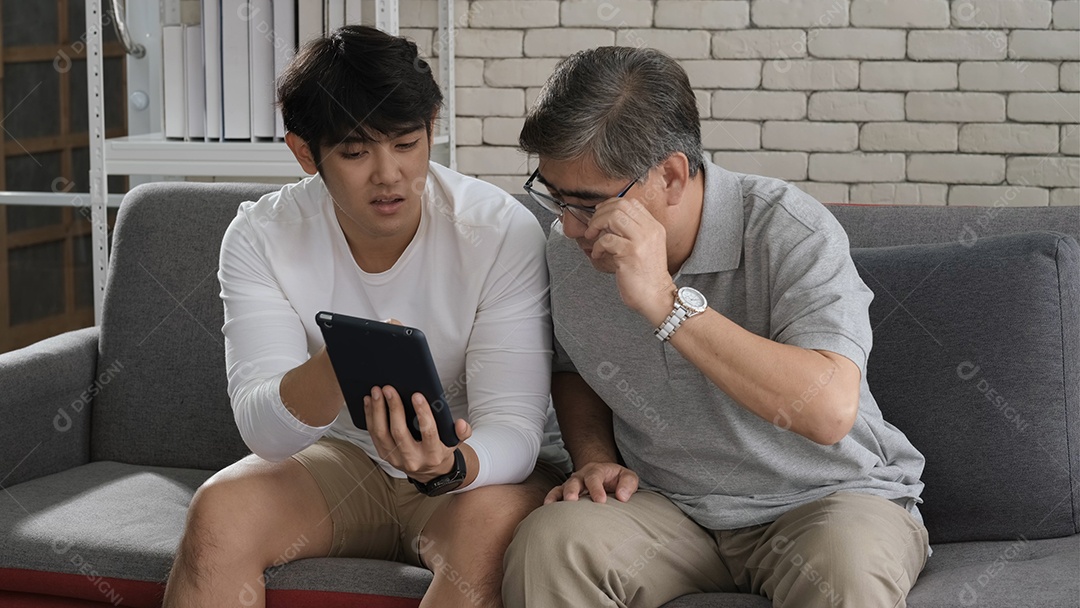 Asiáticos de duas gerações de idade, homens, família, velho pai, jogando videogames