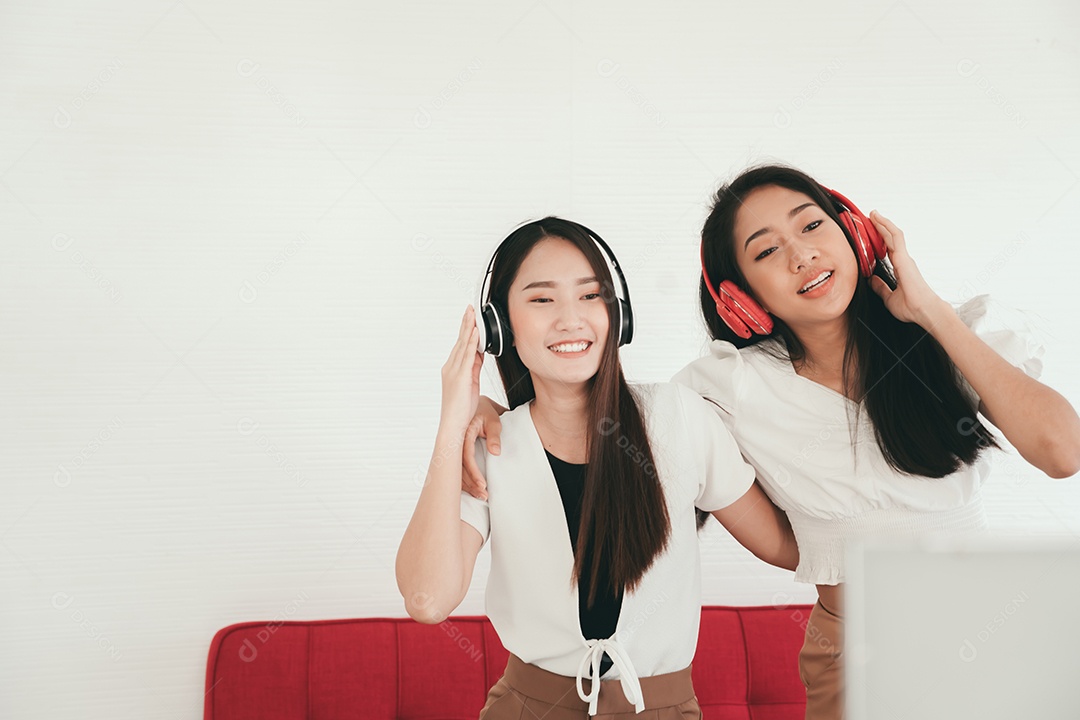 Duas jovens asiáticas felizes dançando e cantando juntas