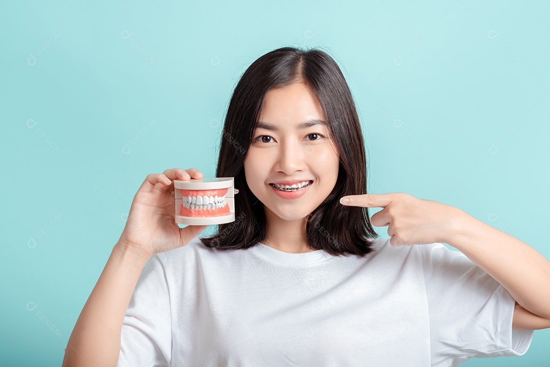 Aparelho dentário de mulher asiática usando aparelho com amostra de dente