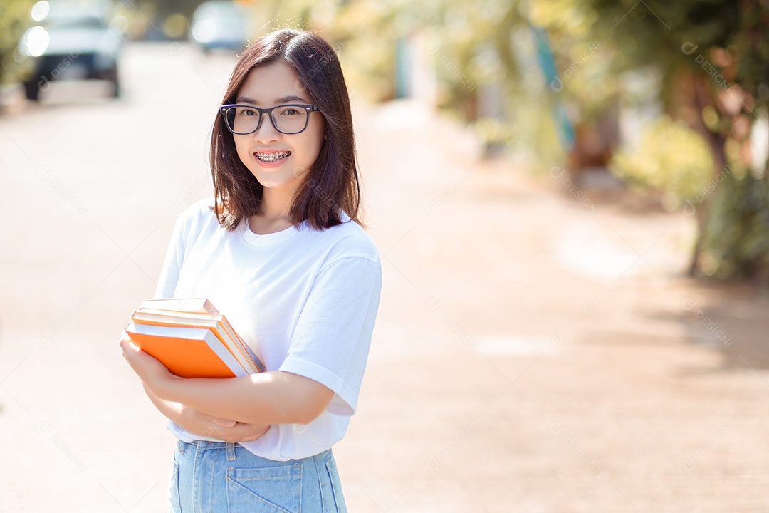 Mulher jovem estudante sorridente segurando livros