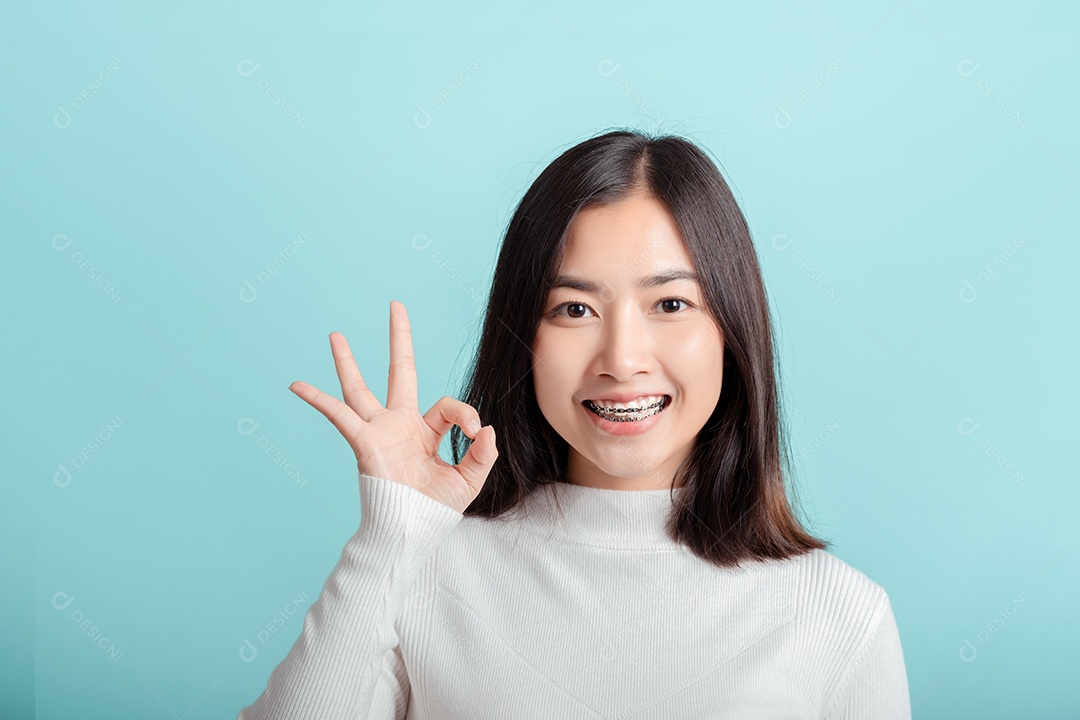 O aparelho dentário da jovem mulher asiática usando aparelho