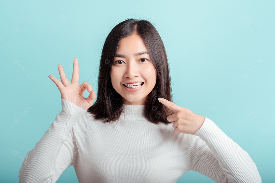 O aparelho dentário da jovem mulher asiática usando aparelho