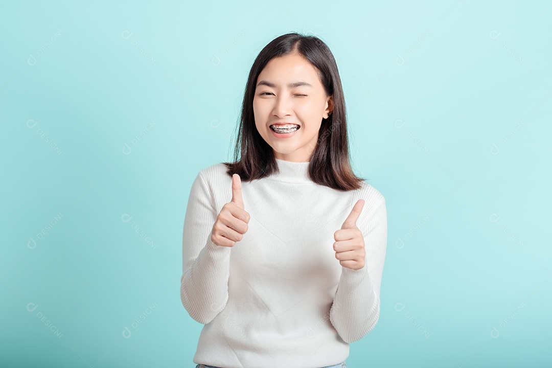 O aparelho dentário da jovem mulher asiática usando aparelho