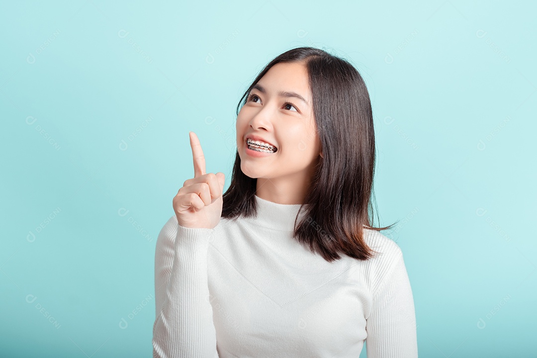 O aparelho dentário da jovem mulher asiática usando aparelho