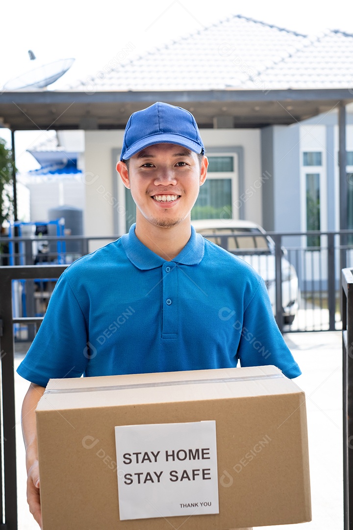 O serviço de entrega masculino de uniforme fornece um pacote de caixa de papelão para o cliente receptor na frente de casa