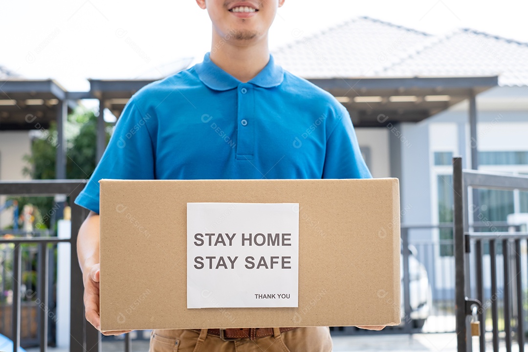 O serviço de entrega masculino de uniforme fornece um pacote de caixa de papelão para o cliente receptor na frente de casa