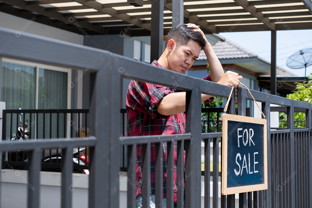 Homem colocando placa de venda de casa