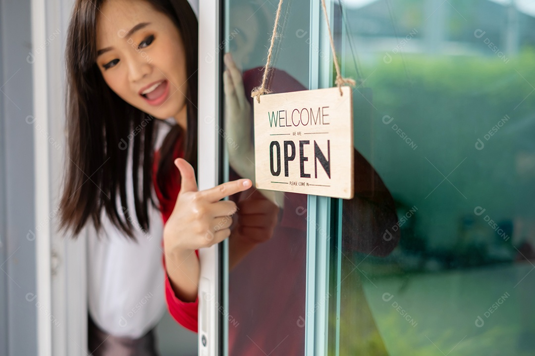 Mulher asiática abrindo porta da loja com placa