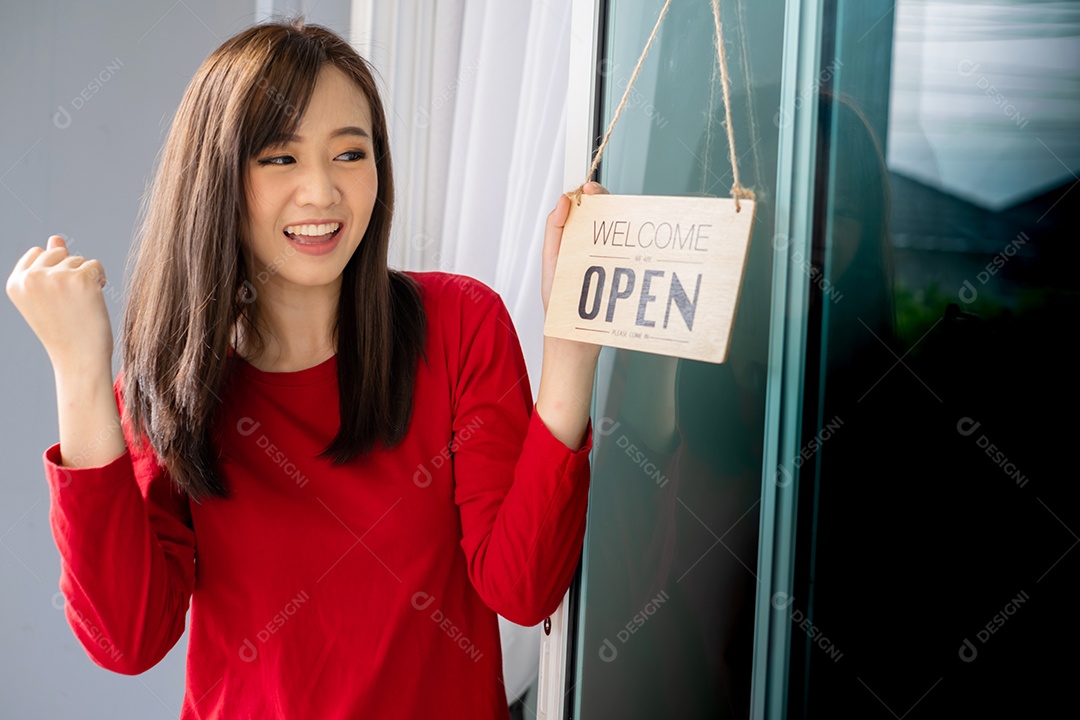 Mulher asiática abrindo porta da loja com placa