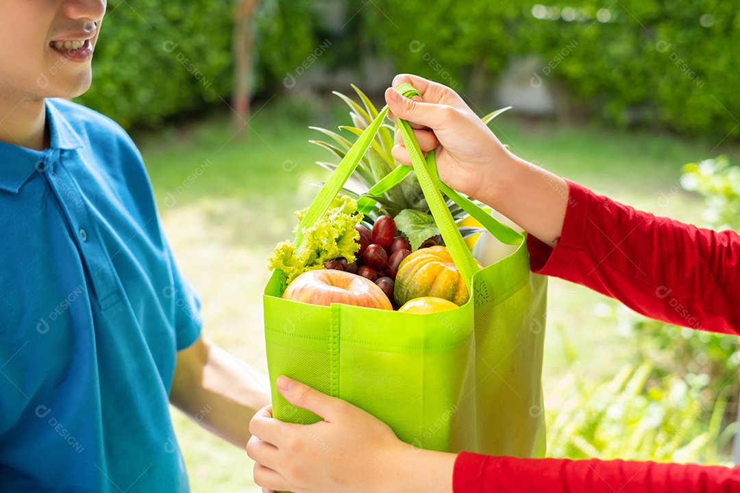 O homem asiático entregador de comida com uniforme azul