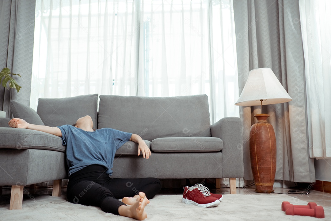 Após o treino da jovem mulher asiática sentada, tire os sapatos apertados