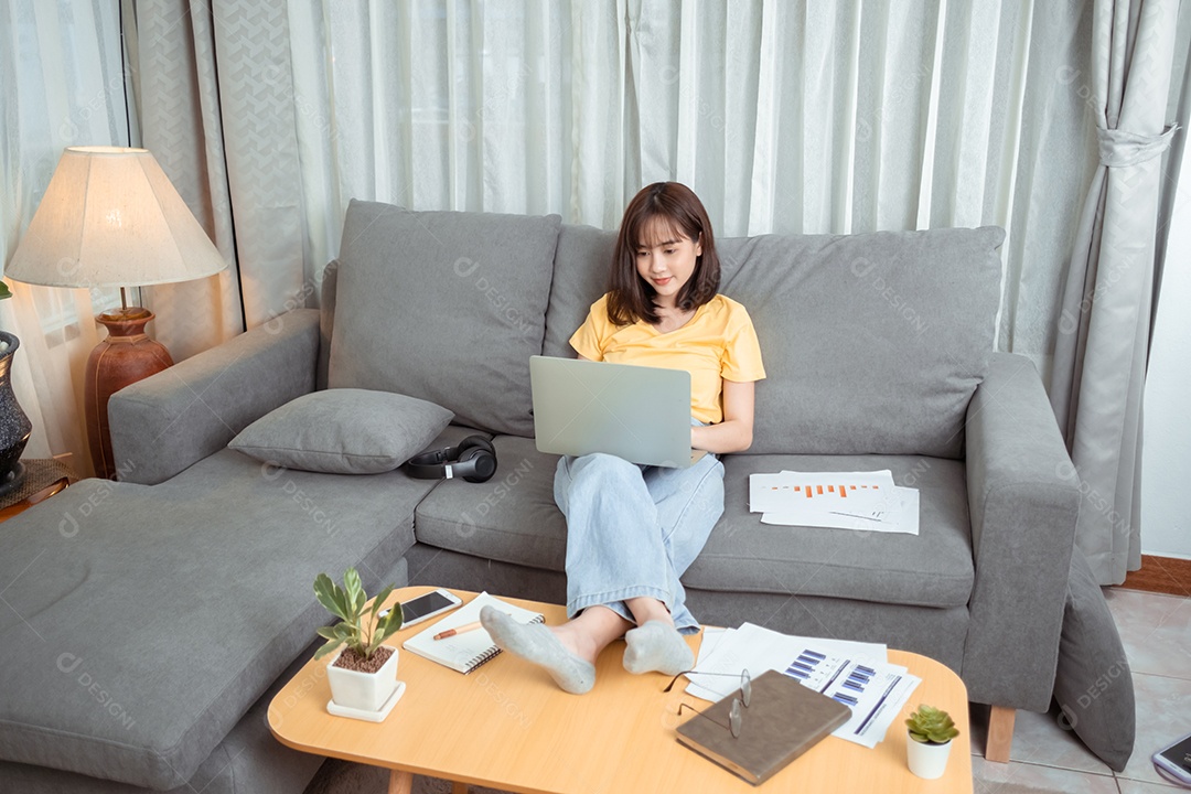 Jovem asiática usando fones de ouvido conversando por vídeo com amigos