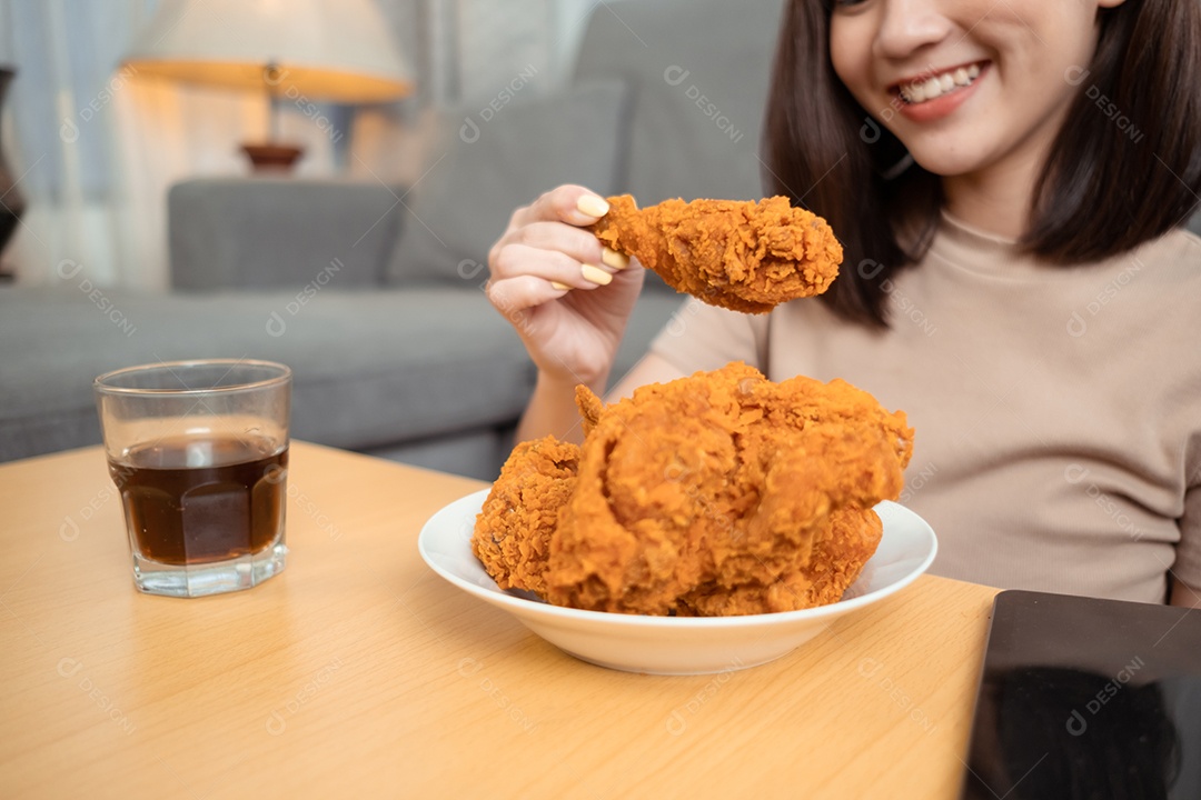 Jovem mulher asiática comendo frango frito desfrutando do serviço de entrega de fast food