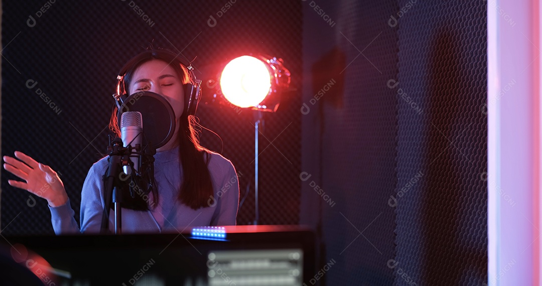 Mulher asiática gravando nova música no estúdio de som