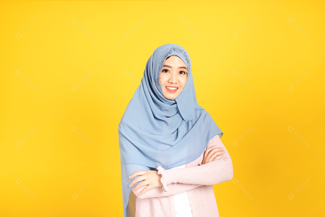Retrato de menina muçulmana asiática usando hijab no estúdio amarelo.