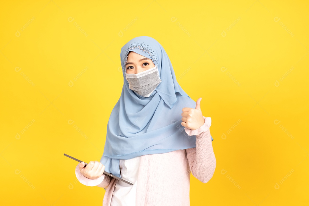 Mulher jovem muçulmana de hijab e máscara facial protetora