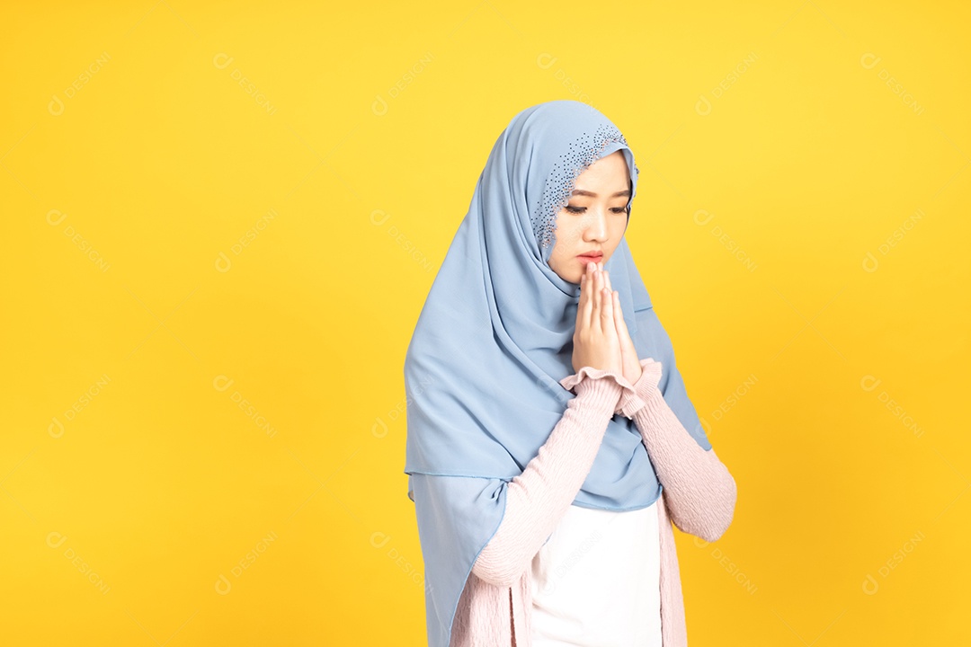 Retrato de uma menina muçulmana asiática em hijab em fundo amarelo