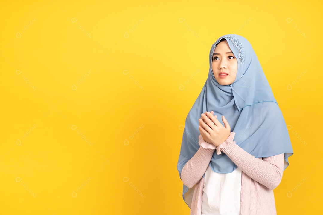 Retrato de uma menina muçulmana asiática em hijab em fundo amarelo