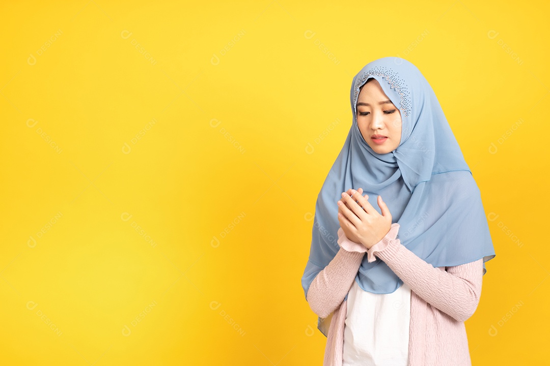 Retrato de uma menina muçulmana asiática em hijab em fundo amarelo