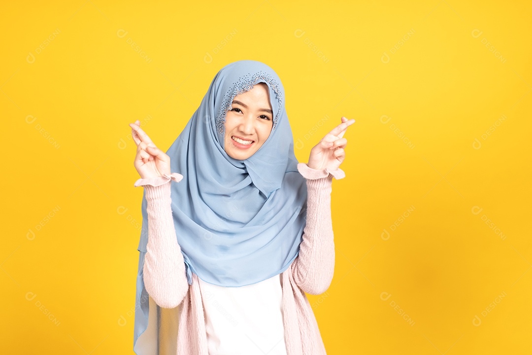Retrato da menina muçulmana asiática no hijab em fundo amarelo