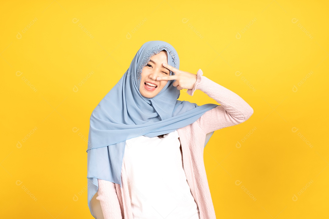 Retrato da menina muçulmana asiática no hijab em fundo amarelo