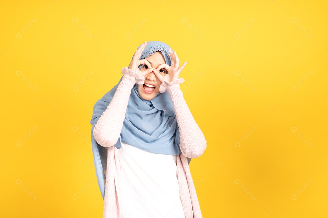 Retrato da menina muçulmana asiática no hijab em fundo amarelo