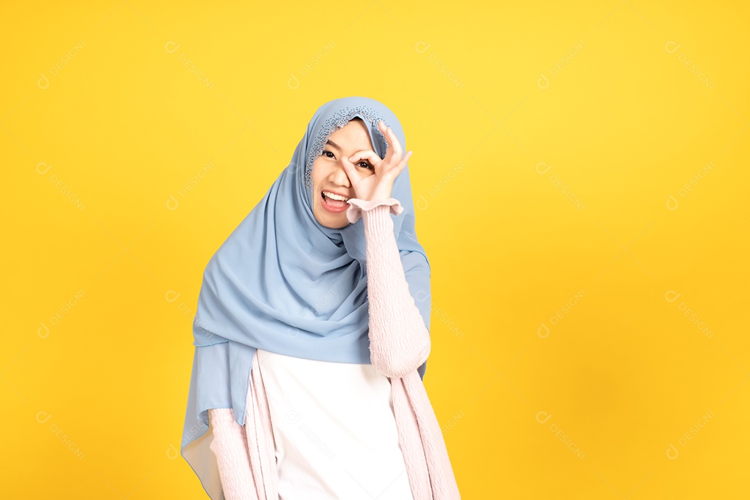 Retrato da menina muçulmana asiática no hijab em fundo amarelo
