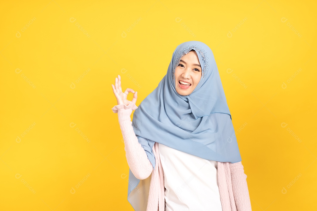 Retrato da menina muçulmana asiática no hijab em fundo amarelo