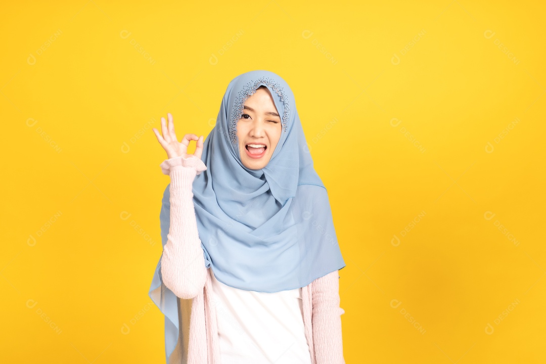 Retrato da menina muçulmana asiática no hijab em fundo amarelo