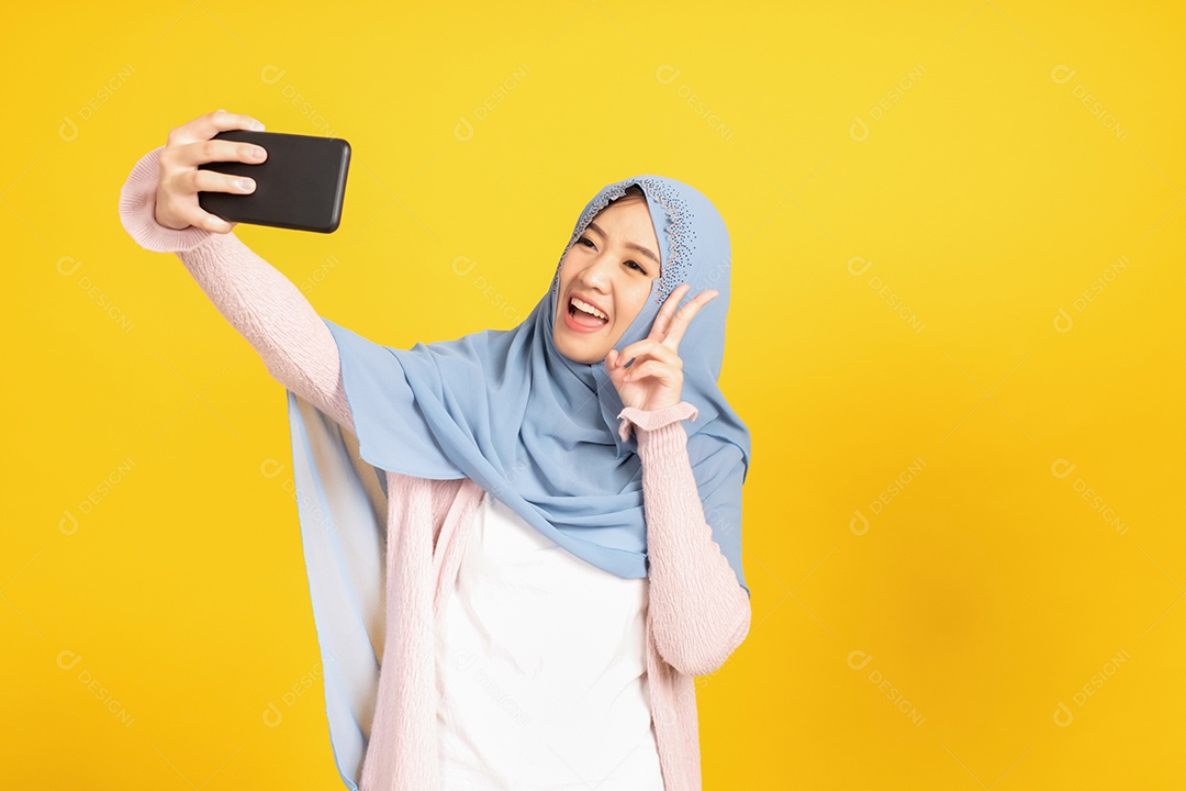 Retrato de menina muçulmana asiática em hijab em fundo amarelo