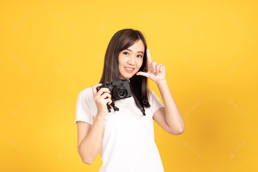 Jovem fotógrafa sorridente com câmera em fundo amarelo