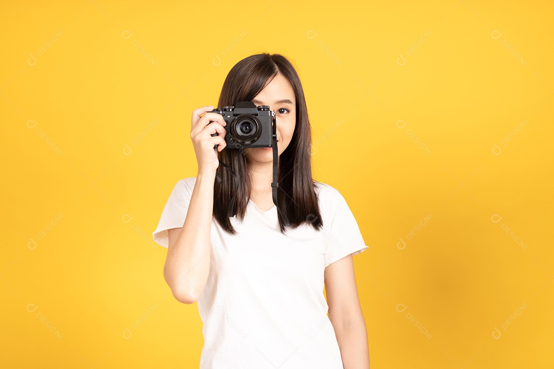 Jovem fotógrafa sorridente com câmera em fundo amarelo