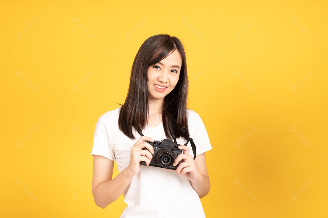 Jovem fotógrafa sorridente com câmera em fundo amarelo
