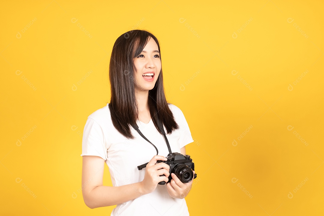 Jovem fotógrafa sorridente com câmera em fundo amarelo