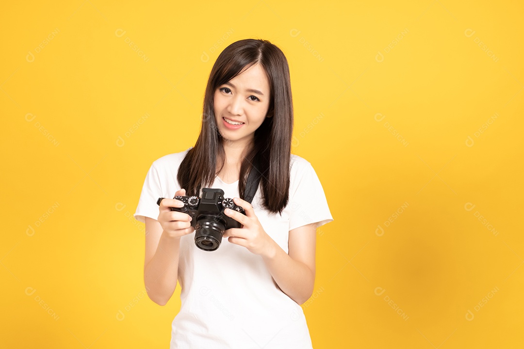 Jovem fotógrafa sorridente com câmera em fundo amarelo