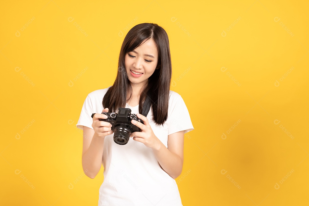 Jovem fotógrafa sorridente com câmera em fundo amarelo