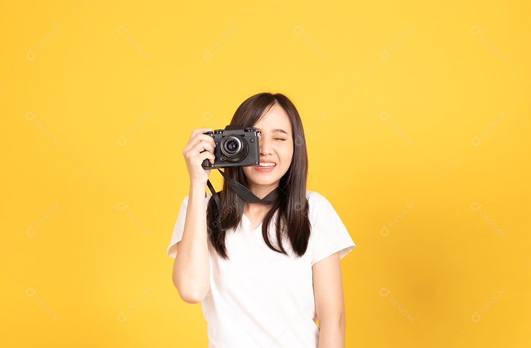 Feliz sorridente jovem fotógrafo asiático tira imagens com a câmera