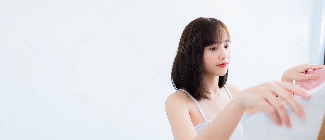 Mulher asiática escolhendo roupas olhando no espelho