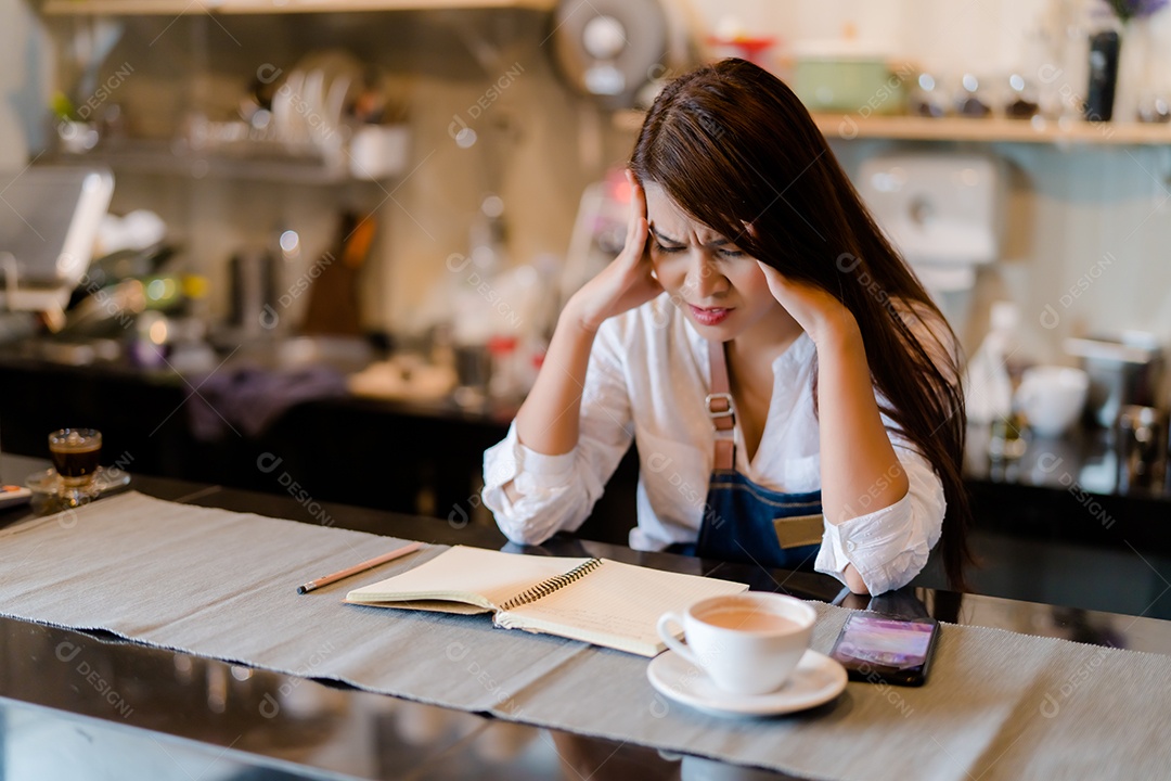 Uma barista asiática está estressada por causa das condições econômicas