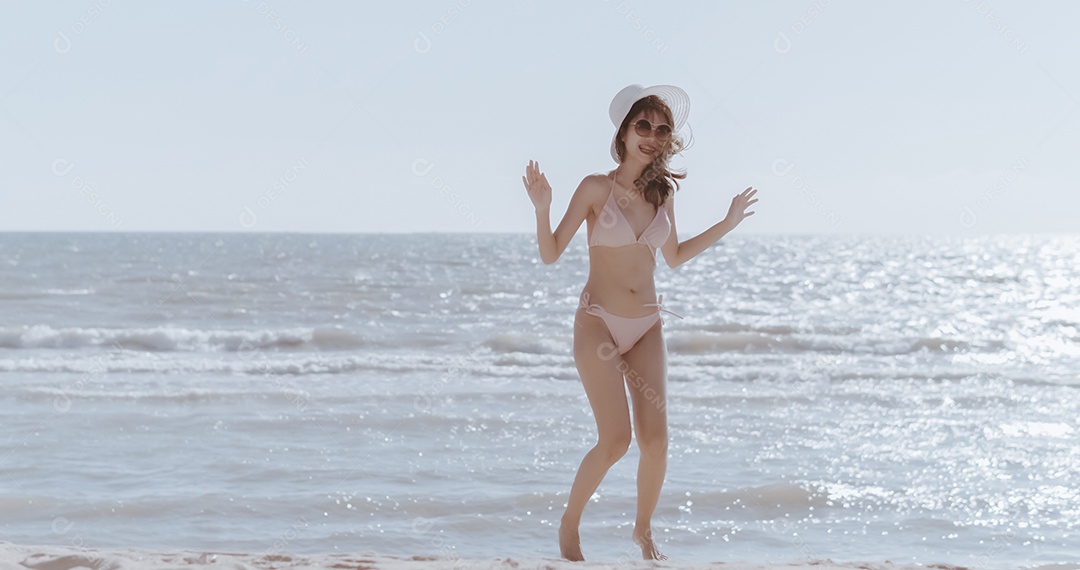 Jovem mulher asiática na praia tropical descansando e relaxando