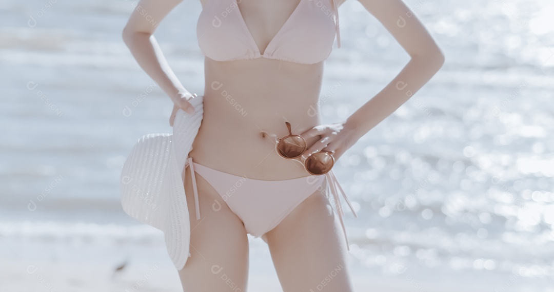 Linda mulher jovem curtindo férias na praia de biquini