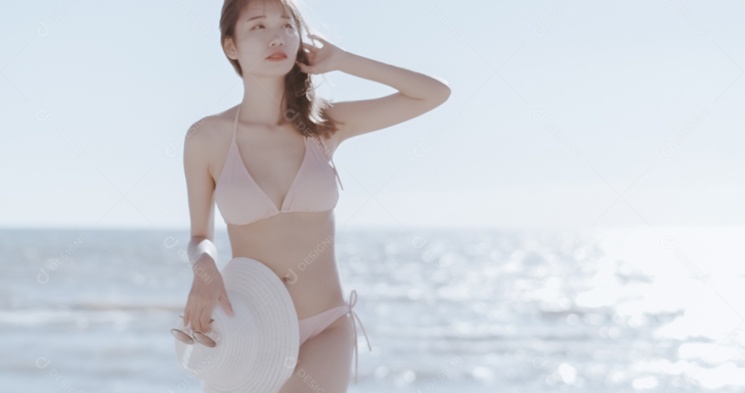 Linda mulher jovem curtindo férias na praia de biquini