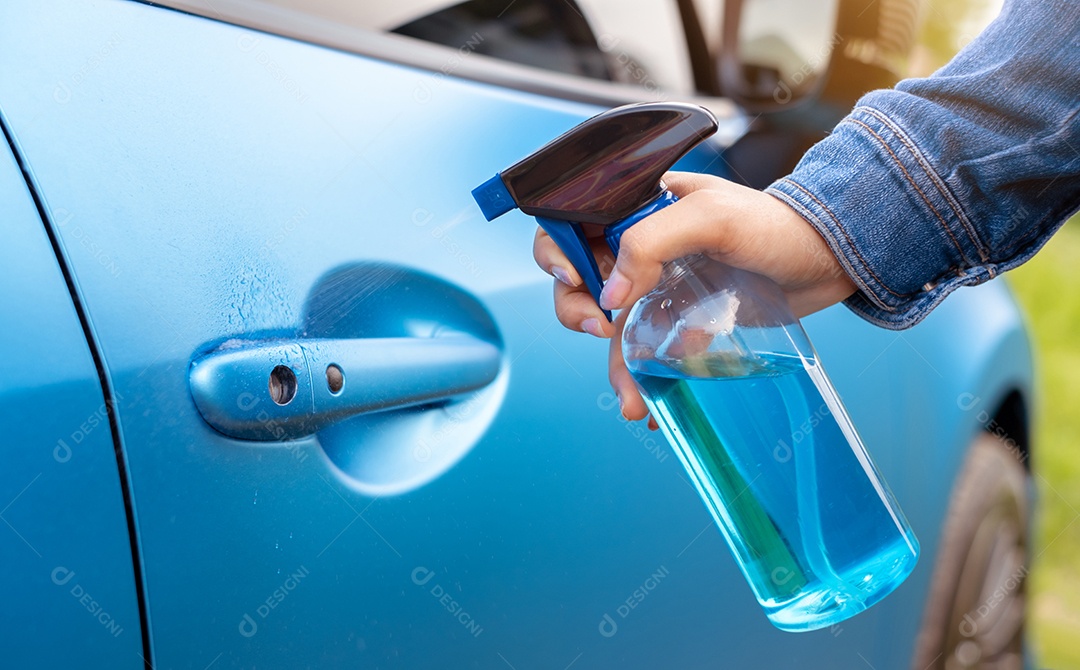 Mão da mulher que limpa o soquete da maçaneta da porta do carro