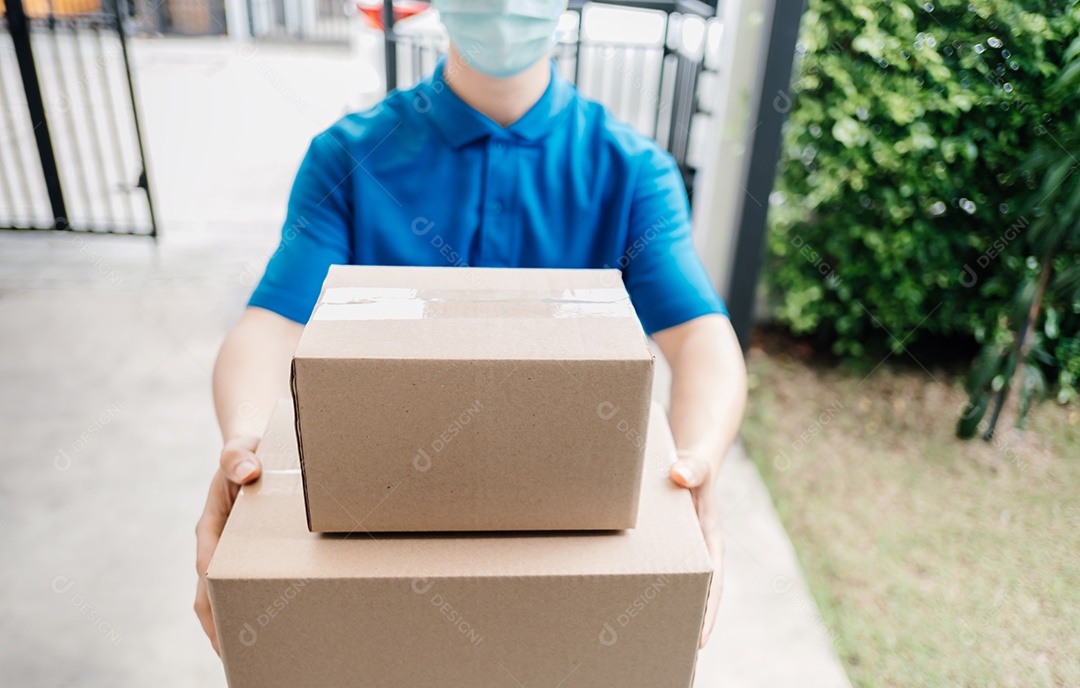 O entregador asiático usando máscara pegando o pacote no transporte para entregas
