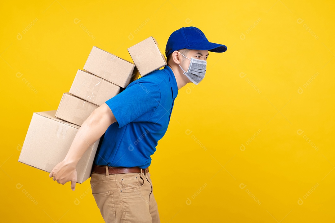 Homem bonito de entrega usando máscara com muitas caixas de papelão pesadas