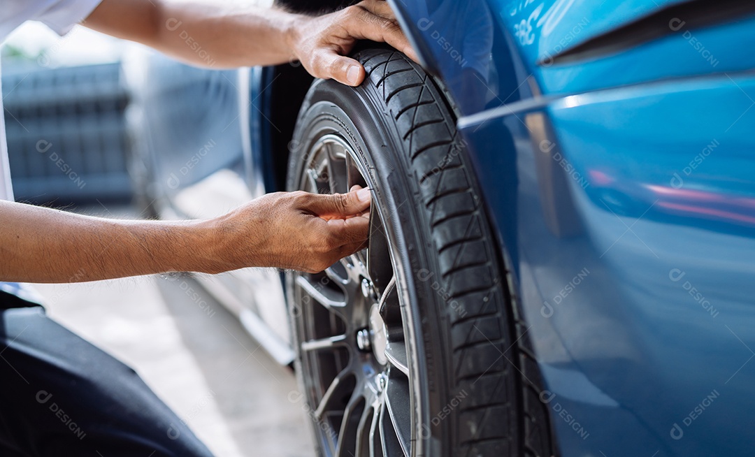 Homem asiático mecânico examinando e arrumando carro do cliente