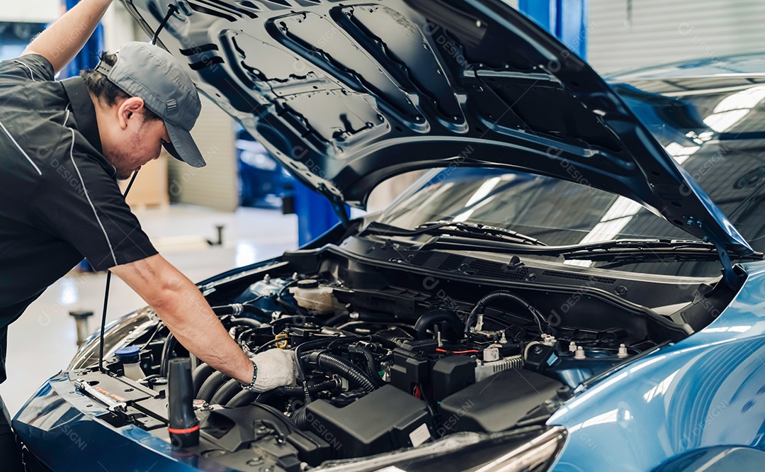 Homem asiático mecânico examinando e arrumando carro do cliente