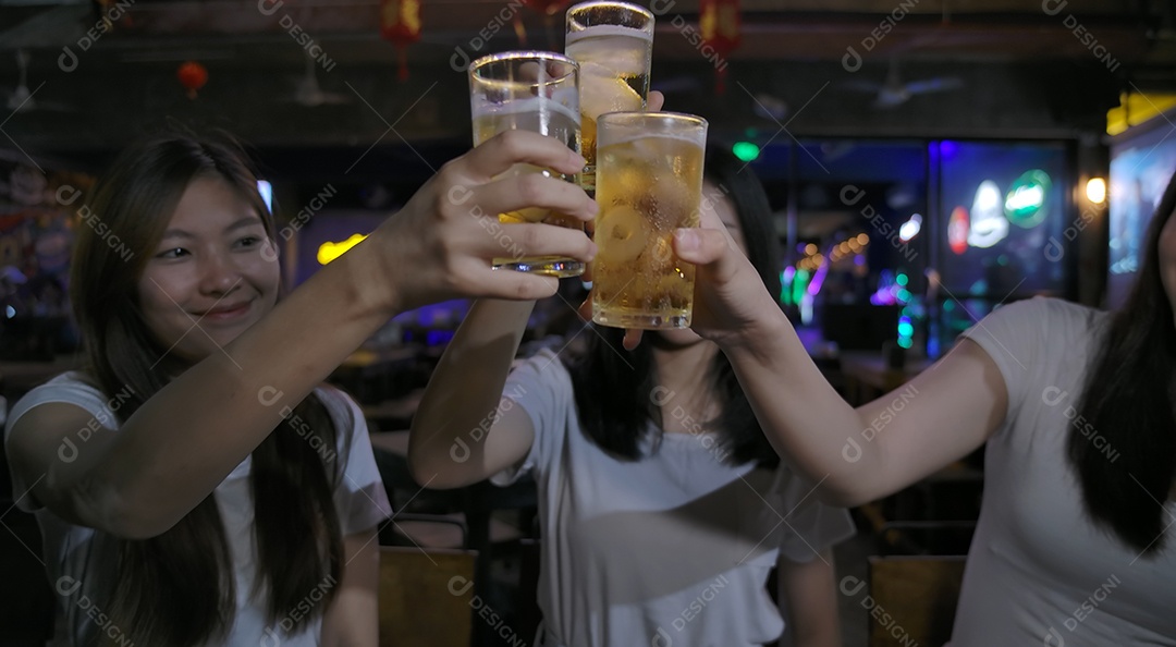 Amigos de mulheres asiáticas festejando e bebendo álcool